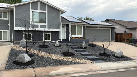 Modern gray two-story house with solar panels and gravel landscaping